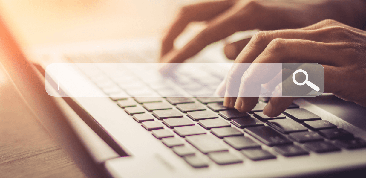 closeup of hands typing on keyboard with a search bar overlay