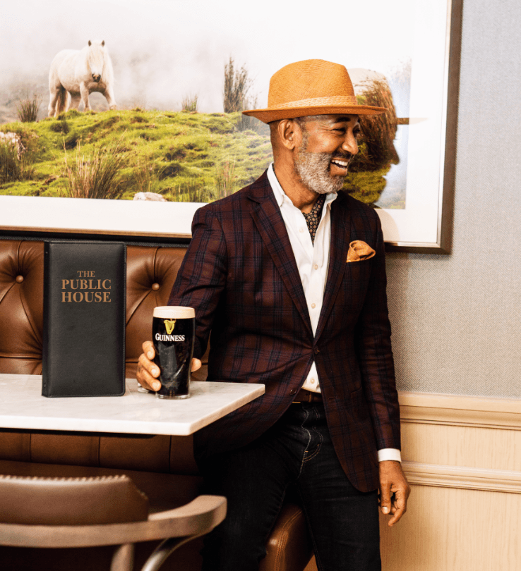 Happy, sophisticated Public House patron drinking Guinness beer