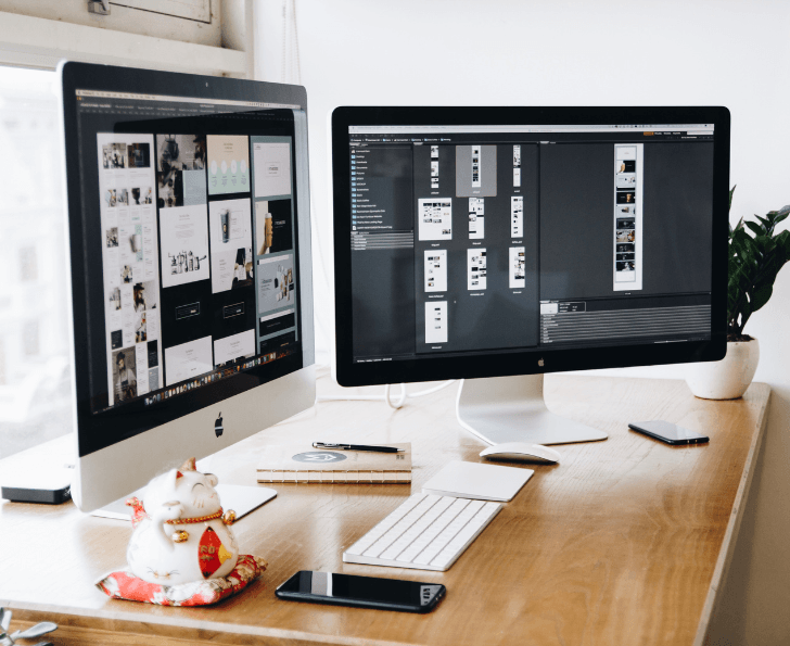 Dual monitors showing the website development process