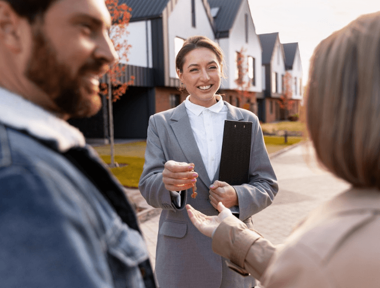 real estate agent handing keys to a happy couple