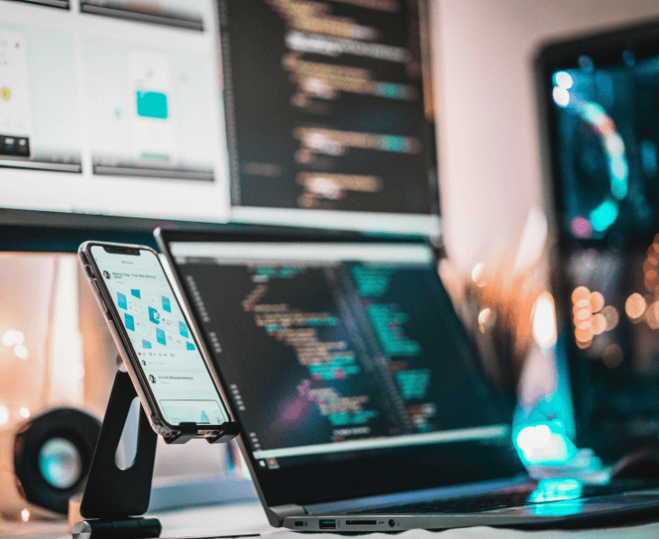 Multiple devices in an office with screens showing QA testing