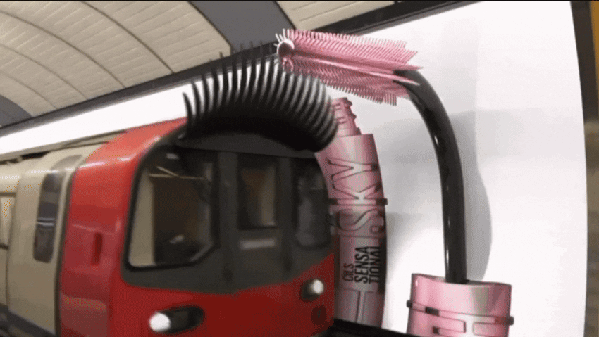 CGI example of giant mascara wands and lashes “applied” to the tops of a London train.
