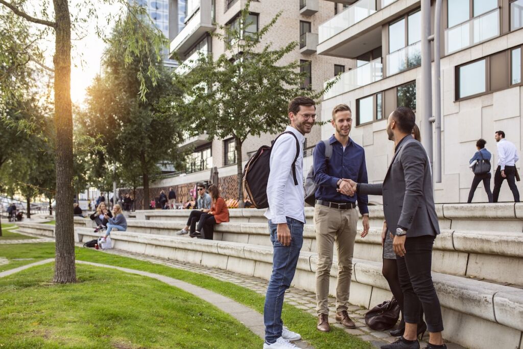 University students networking with professionals on campus, highlighting career outcomes, student success, and higher education marketing that builds trust with prospective applicants.