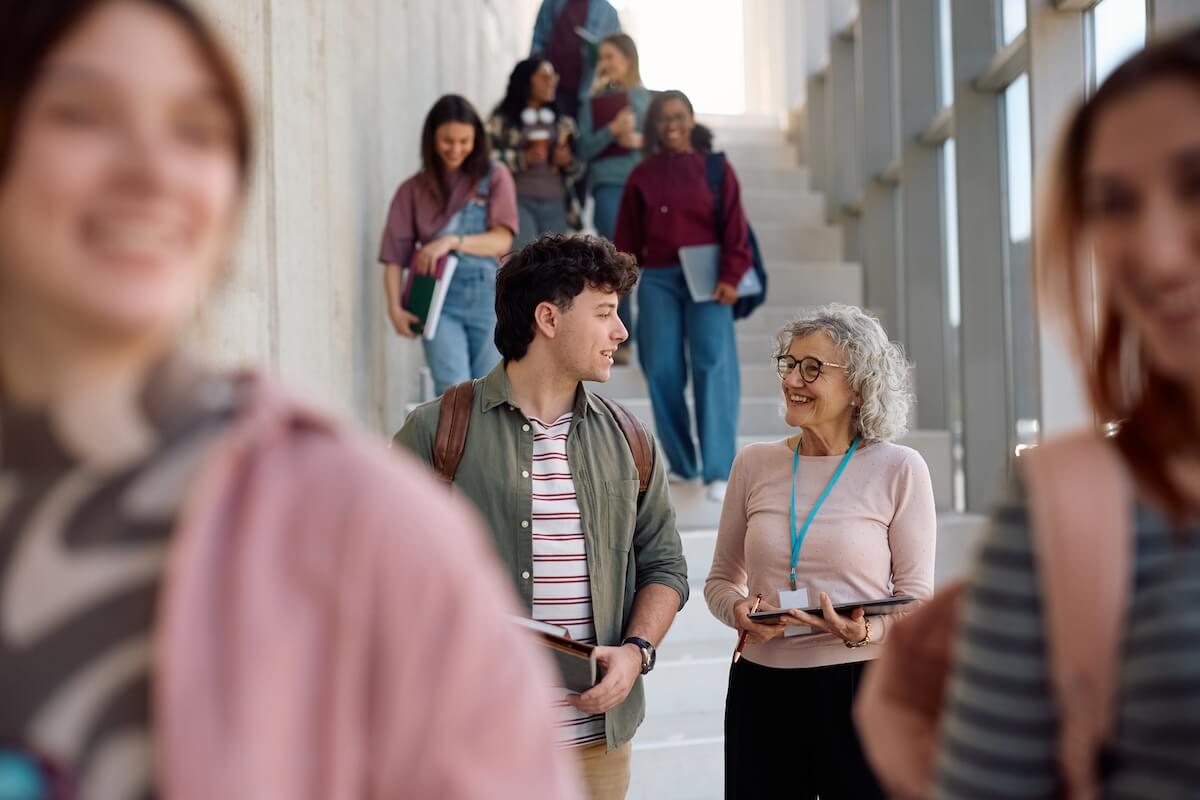 Student speaking with a university professor on campus while walking between classes, representing higher education marketing strategies that build trust and improve student recruitment.