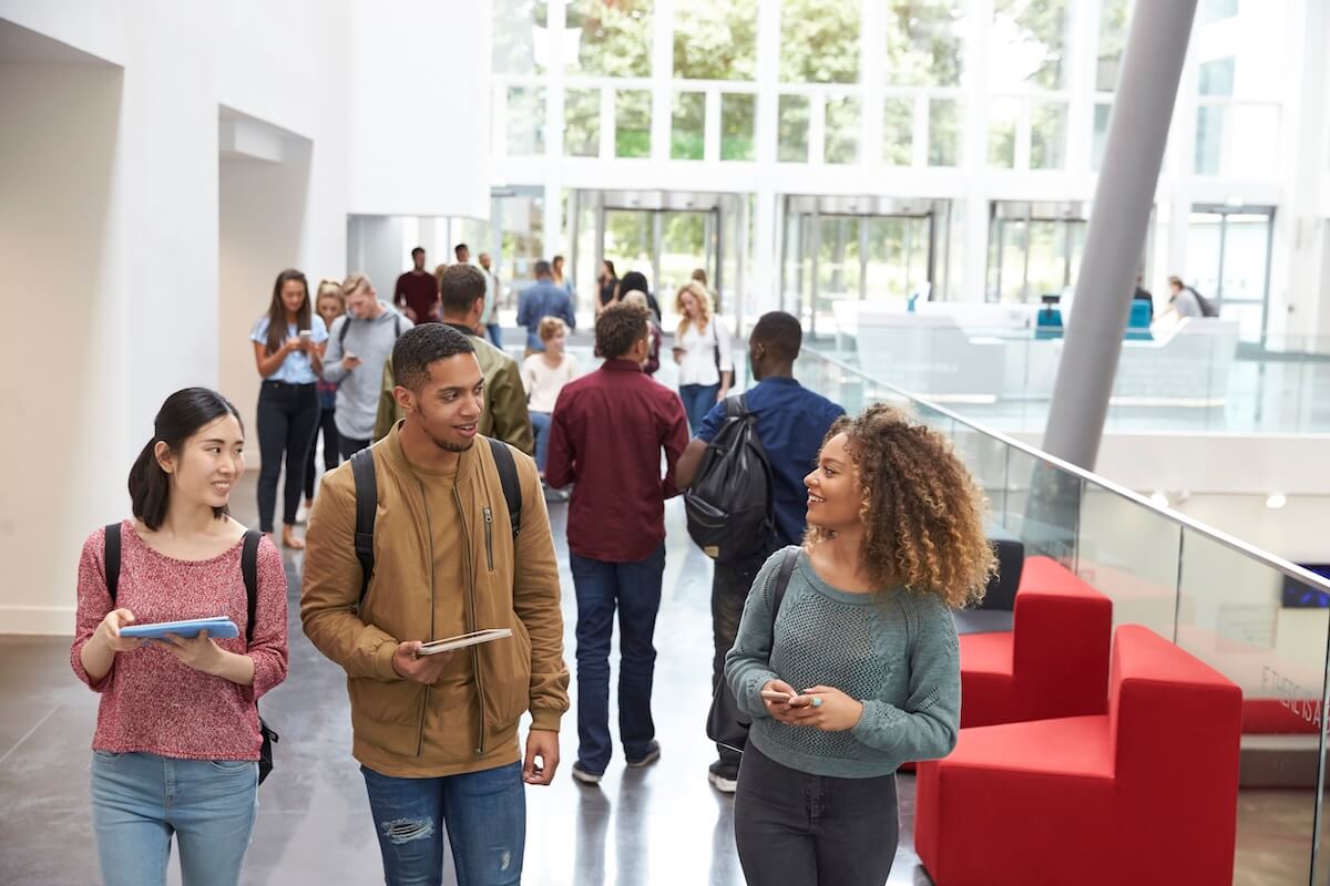 College students walking through a university campus building, illustrating higher education marketing, student recruitment, and enrollment strategies for colleges and universities.