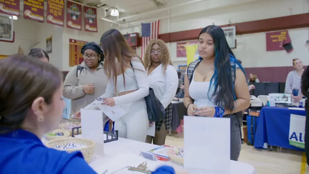 Students at a campus event table, from an LO Media college video shoot